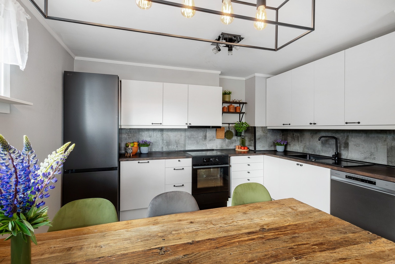 Innredningen har glatte fronter og praktisk benkeplate i tre med kitchen board over. Kjøkkenet ble oppgradert i 2024 med nye hvitevarer, inkludert kjøleskap/fryser, oppvaskmaskin og komfyr. Galleribilde