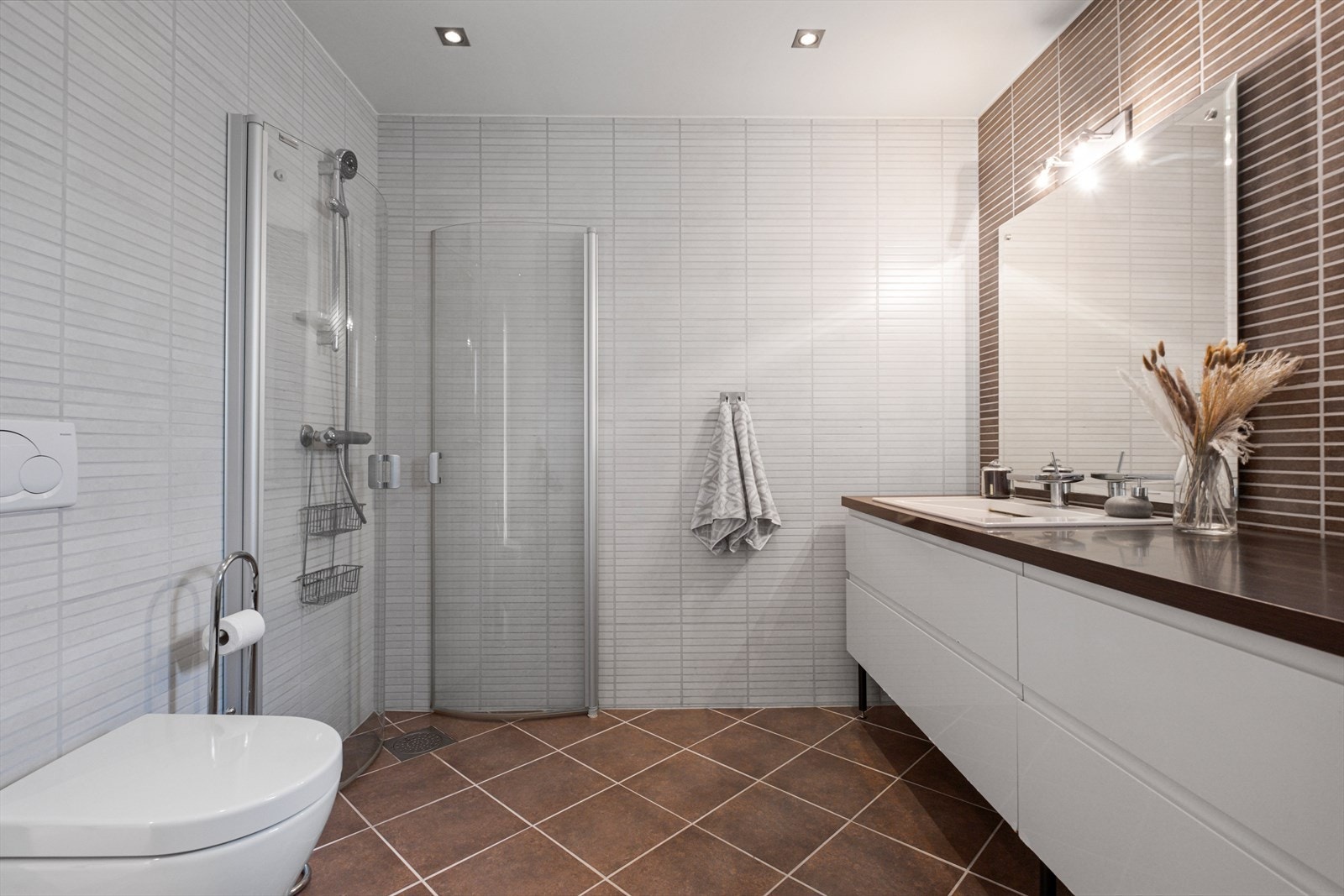 Pent bad i hovedetasjen. På gulv er det fliser og det er vannbåren varme i gulvet. Rommet er
innredet med dusjvegger, baderomsinnredning og vegghengt toalett. Galleribilde