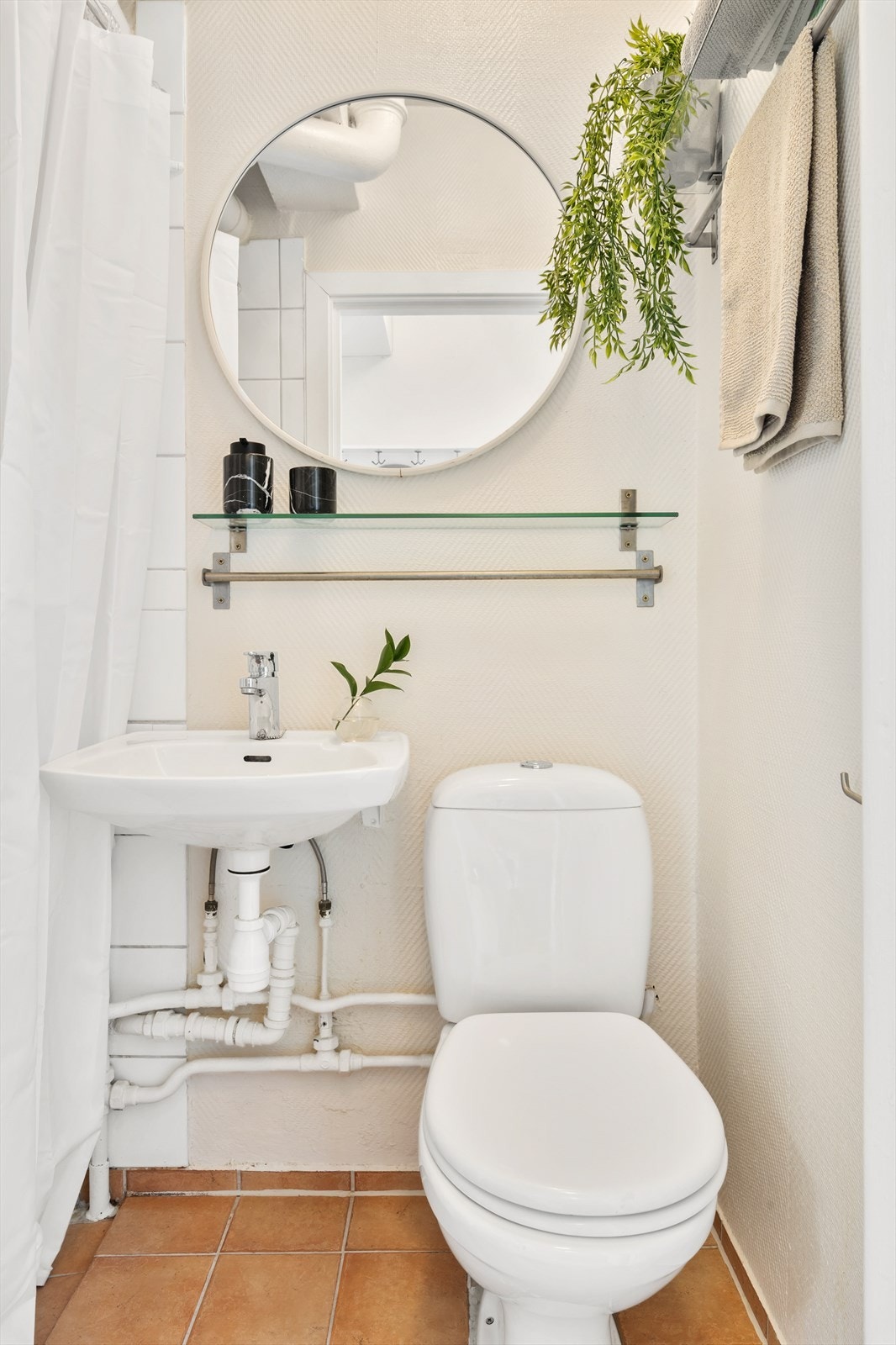 Badet innredet med dusjhjørne med forheng, gulvstående toalett og servant. Baderommet må renoveres for å tåle normal bruk etter dagens krav. Galleribilde