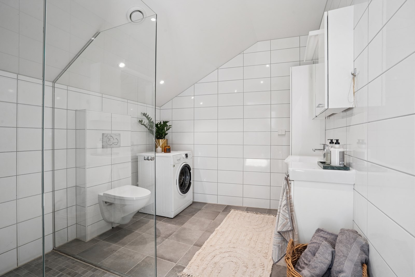 Veggene er kledd i lyse fliser og gulv er kledd i grå fliser som skaper kontrast. Gulv er også utstyrt med varmekabler for en lun temperatur. Galleribilde