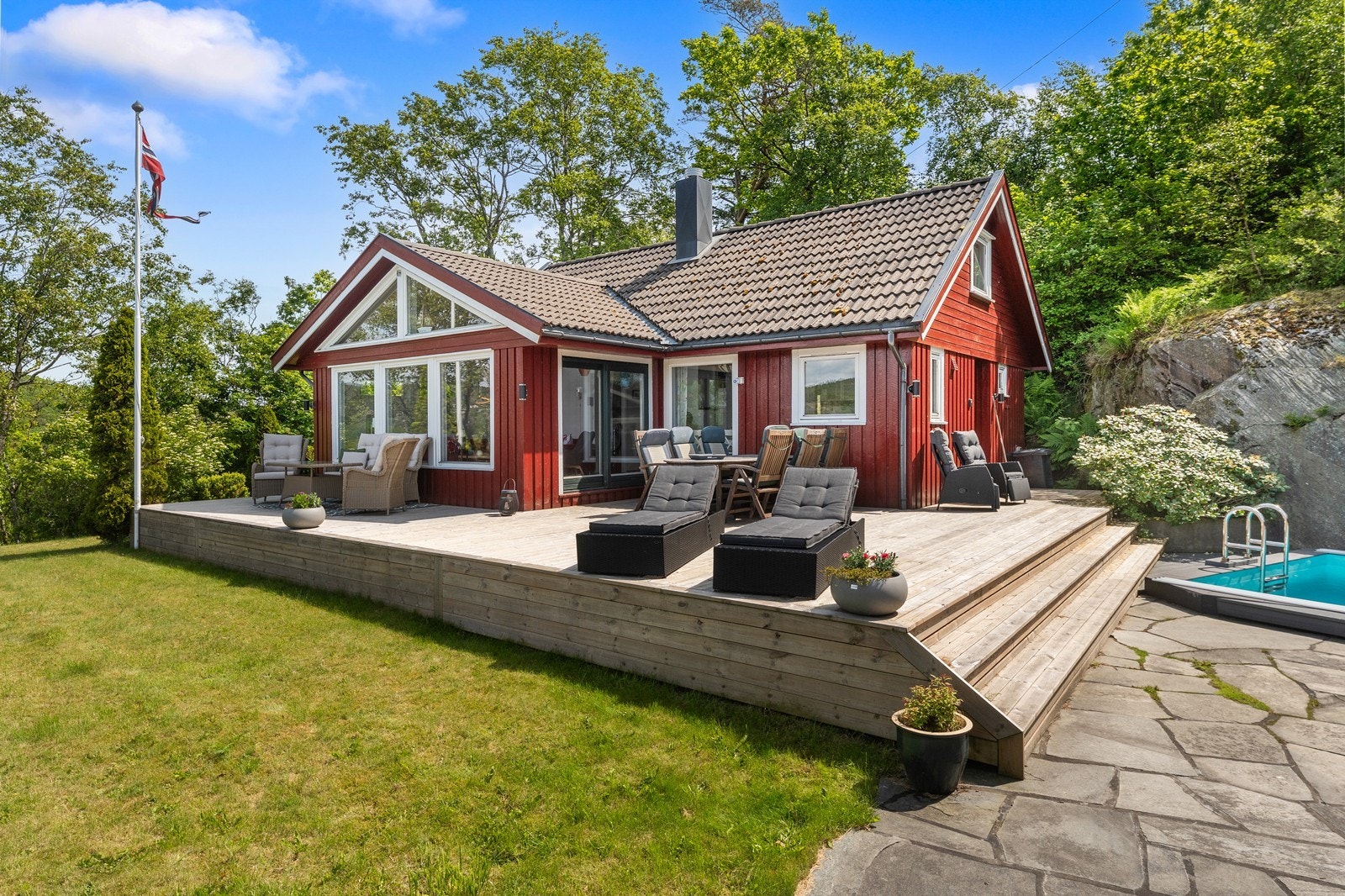 Store terrasser og platting ved bassenget - her er det god plass til det gode sommerlivet på sørlandet Galleribilde