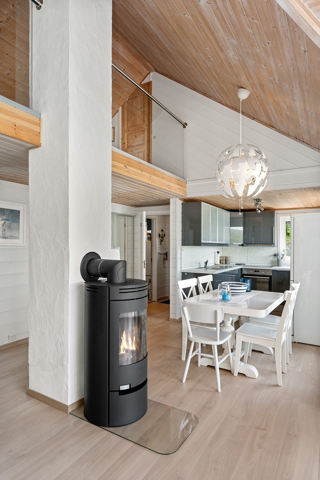 Høy himling og lekkert glassrekkverk på mesaninen gir et luftig og lyst preg i stuerommet Galleribilde