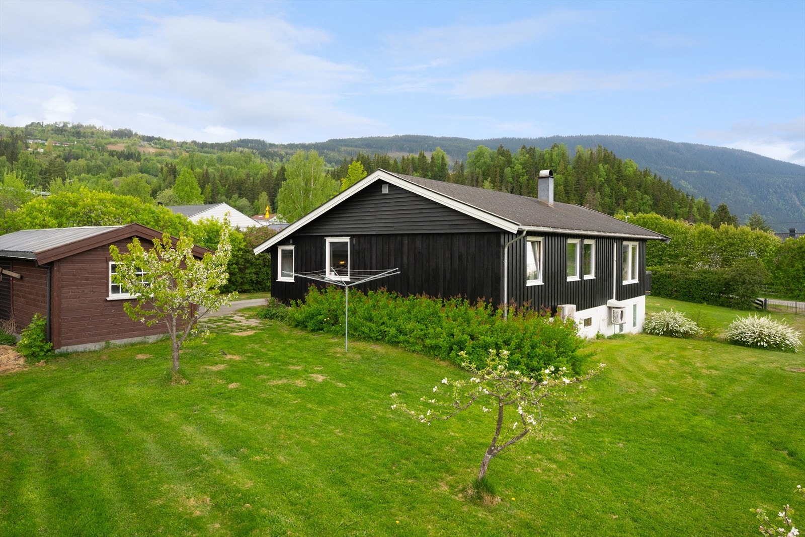 Tomten er pent opparbeidet m/grøntarealer samt busker og trær. Galleribilde