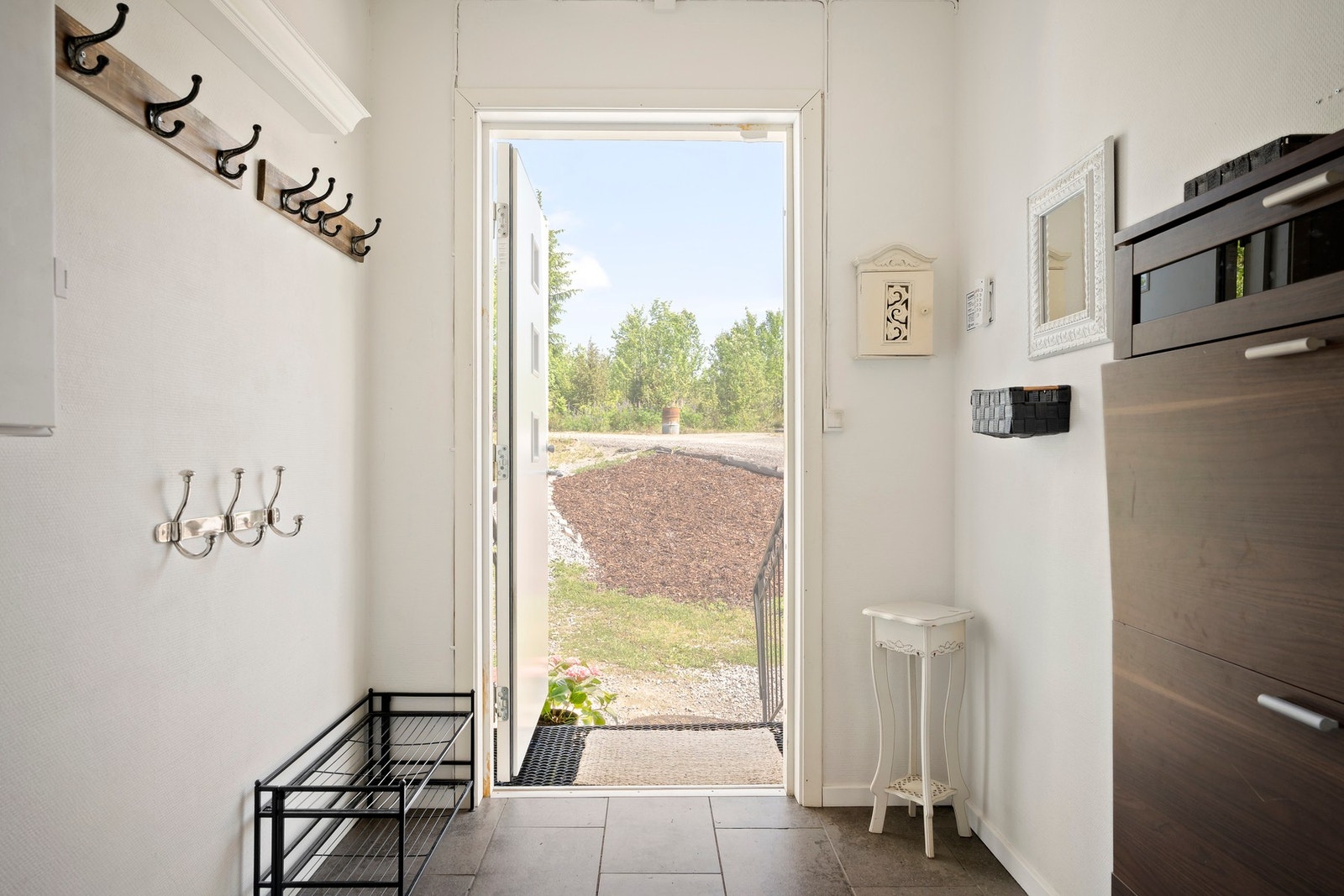 Velkommen inn i en lys og ryddig entré med fliser på gulv og god plass til både sko og yttertøy. Galleribilde