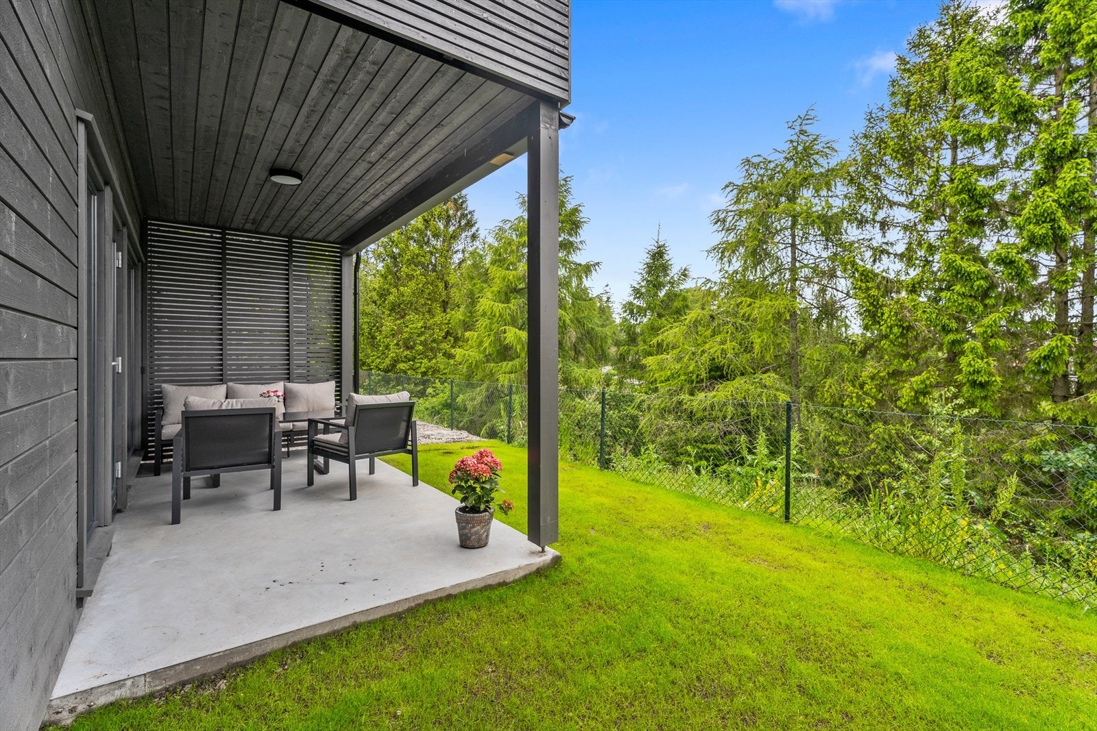 Hyggelig uteområde med betong platting og gressplen Galleribilde