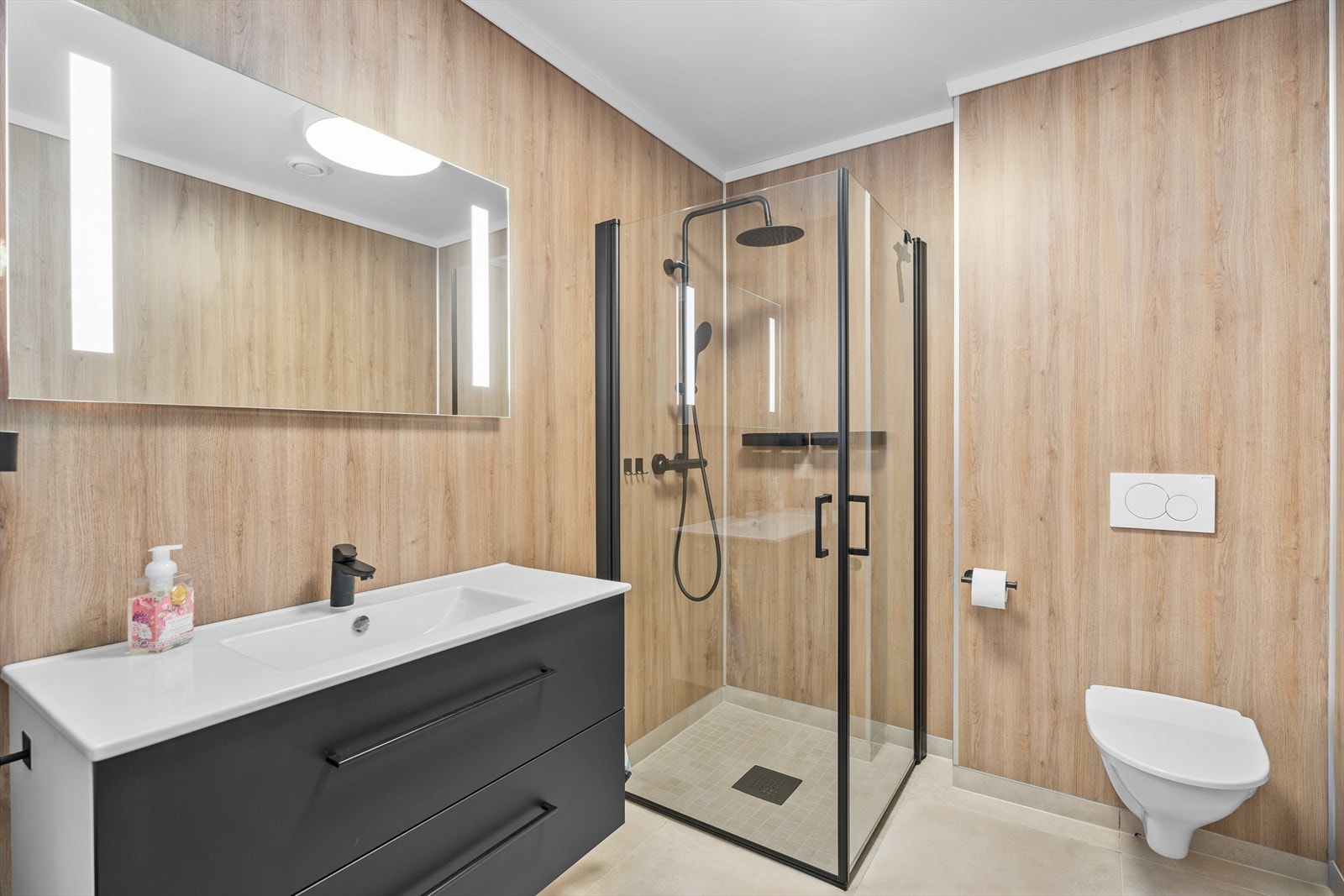 Badet er stilrent med vegger av baderomsplater og tak med malt himling. Galleribilde