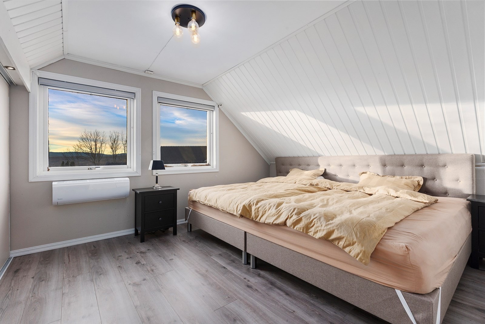 Hovedsoverommet har god plass til dobbeltseng med tilhørende nattbord. Store og gode vinduer bidrar til godt med lys og luft inn. Det er montert varmepumpe på soverommet. Galleribilde