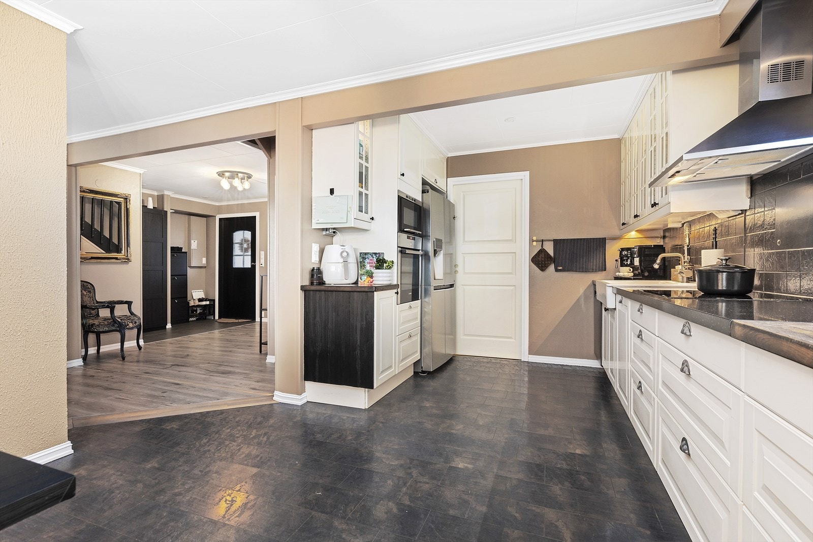 Fra entréen er det videre adkomst til kjøkkenet, som ligger i en delvis åpen løsning mot spisestuen. Galleribilde