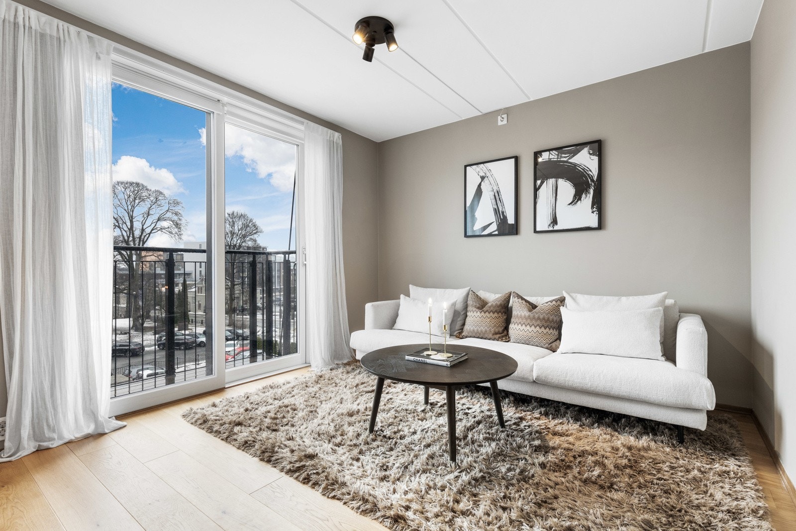 Stuen har parkettgulv, harmonisk farge på vegger og sorte spotter i himling. Galleribilde