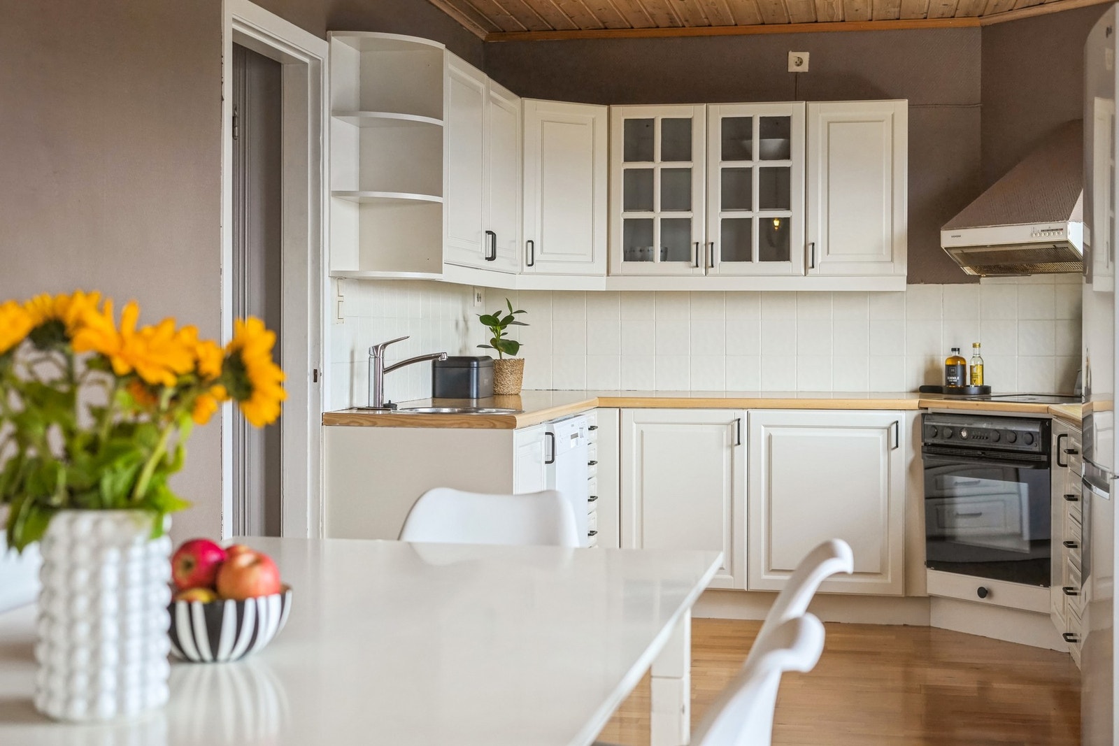 Lys og nøytral kjøkkeninnredning med profilerte fronter. Utformingen byr på god skapplass, og enda bedre arbeidsplass på benk. Galleribilde