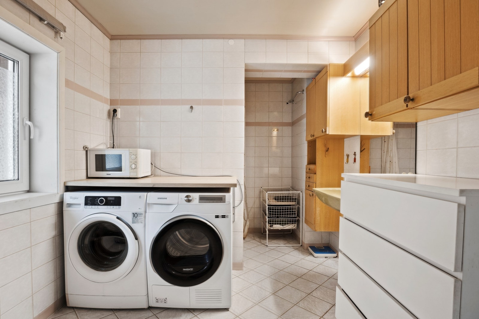 Rommet er innredet som vaskerom og har flislagt gulv med varmekabler, flislagte vegger og malt tak. Galleribilde