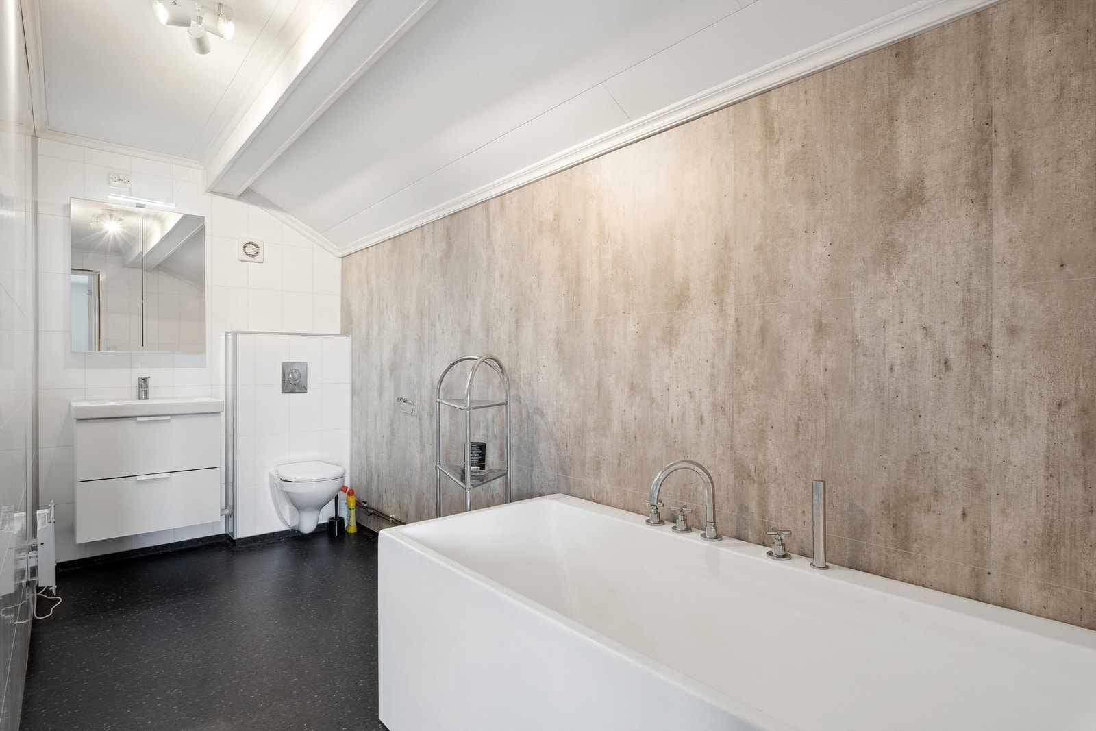 Bad fra 2017 og har vegger med baderomsplater og himlingsplater i taket. Gulvet med vinylbelegg. Innredningen består av nedfelt servant, speil med lys, veggmontert toalett og badekar. Galleribilde