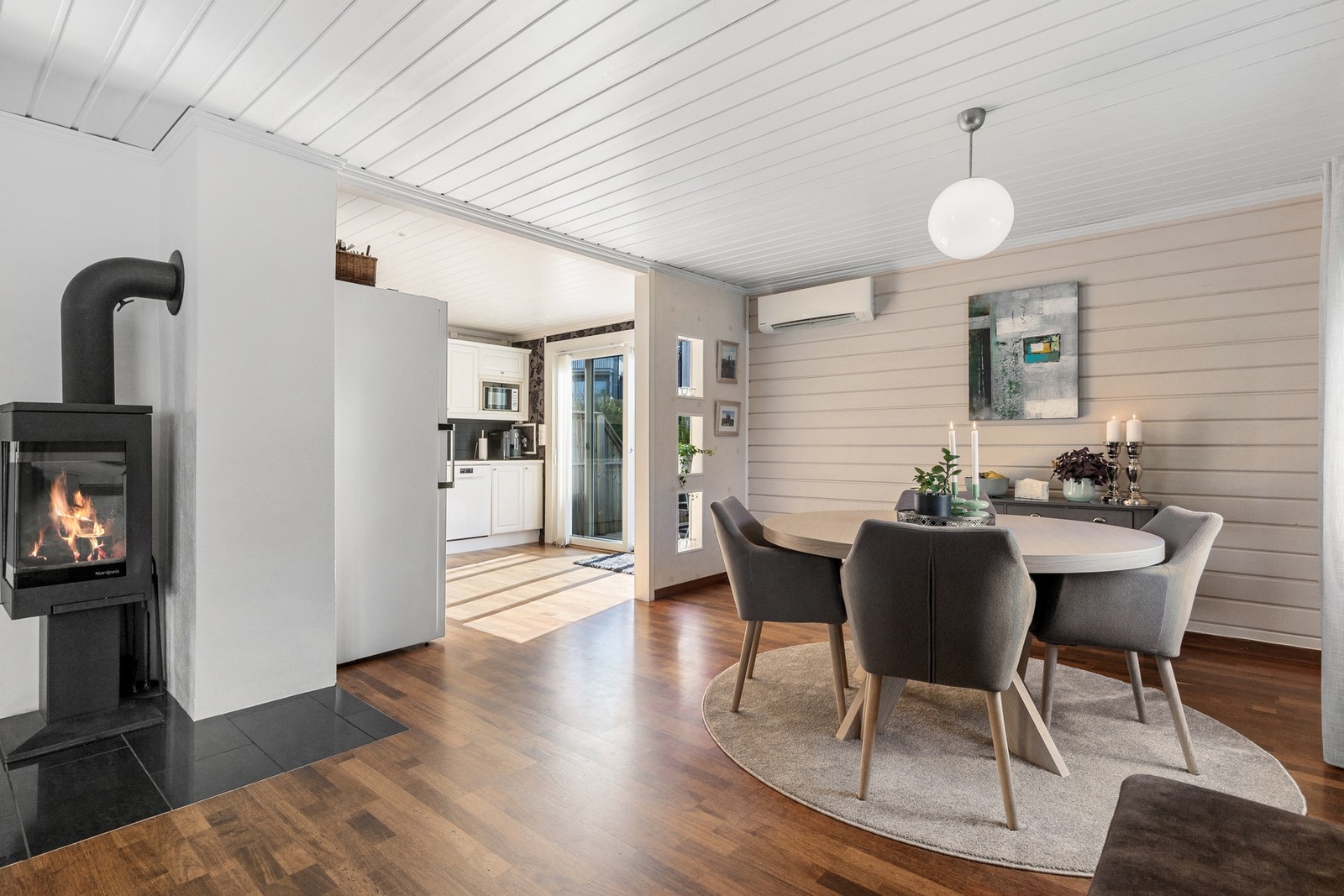 Den åpne løsningen mellom spiseplassen og kjøkkenet gir rom for flere sosiale soner selv ved matlaging Galleribilde