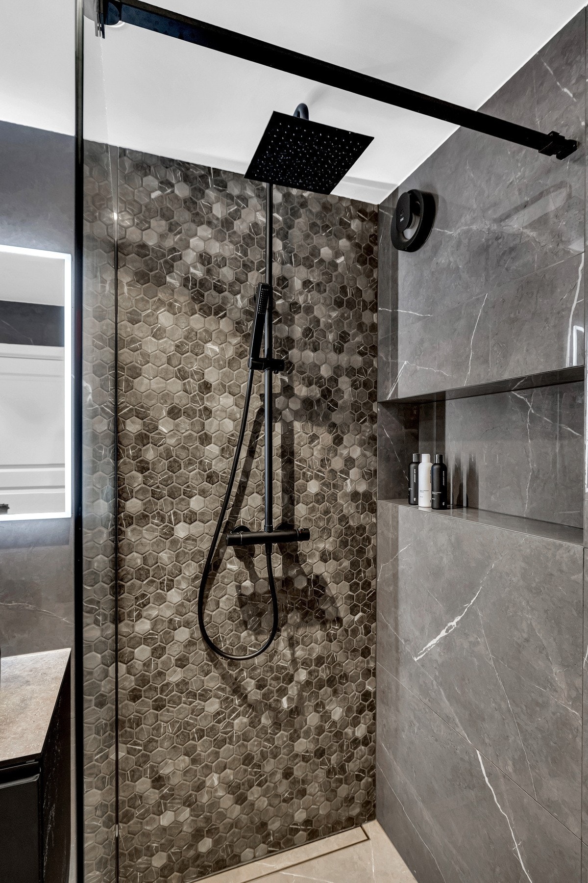 Elegant dusjnisje med mosaikkfliser i naturtoner som gir badet et eksklusivt preg. Galleribilde