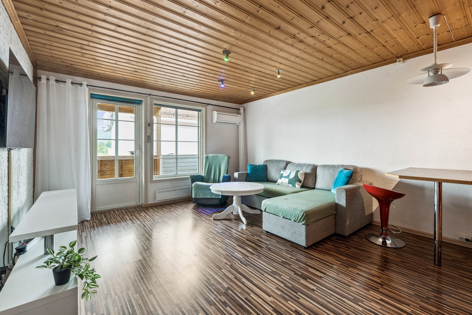 Romslig stue med laminatgulv og malte flater Galleribilde