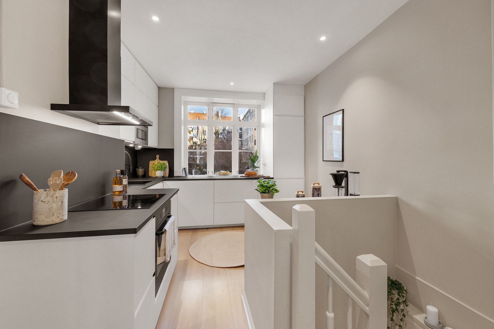 Stilren kjøkkeninnredning fra 2022 med fronter i hvit matt utførelse og benkeplate av laminat. Galleribilde