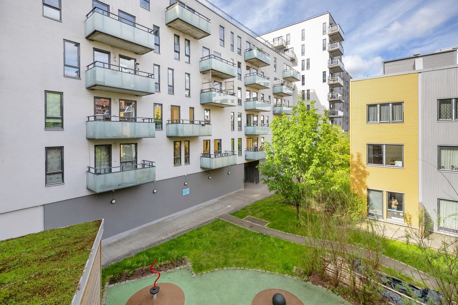 Fasade, fin bakgård med plen og beplantning Galleribilde