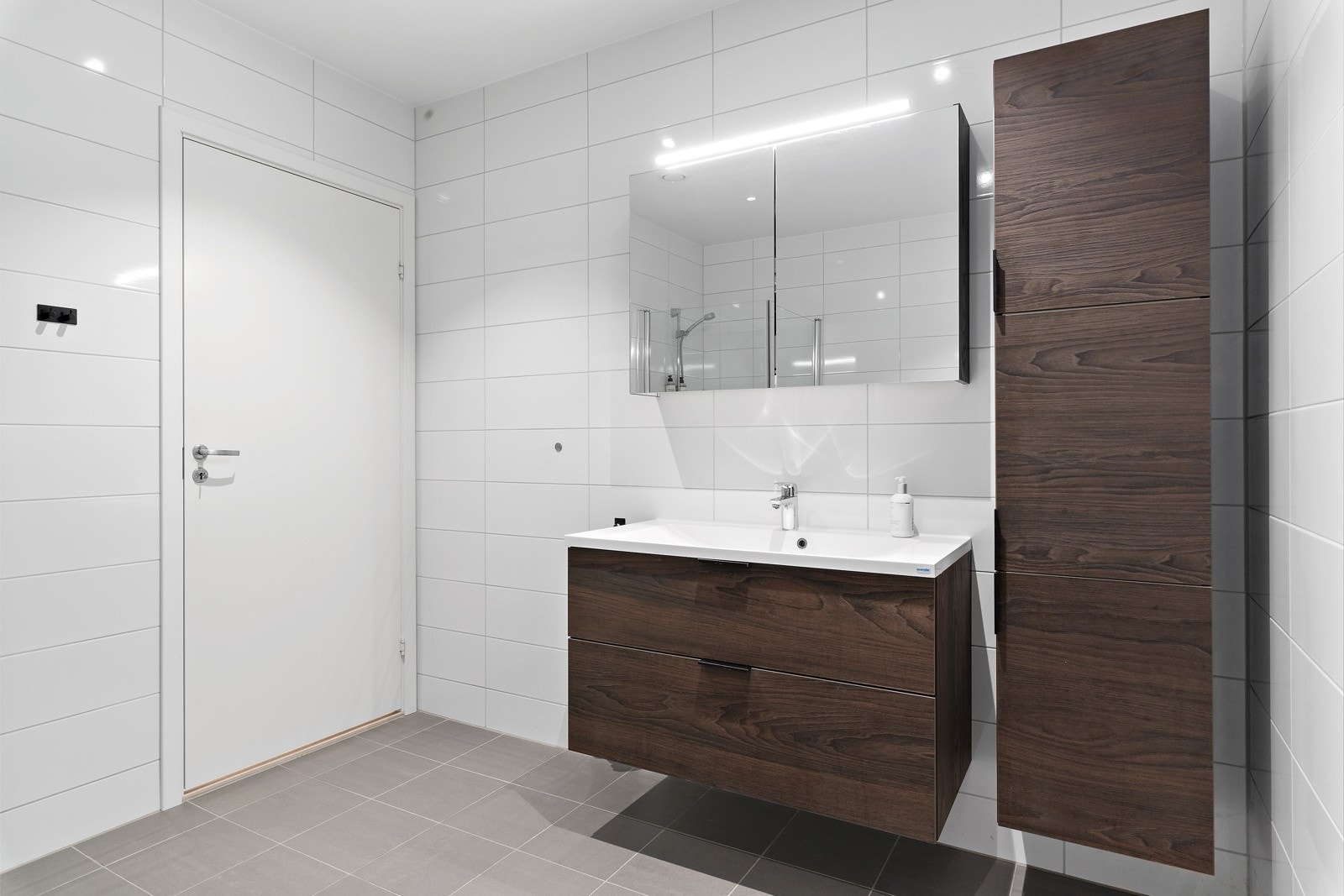 Badet er helfliset med stilrene fliser, har varmekabler, servantskap med finerte fronter og speil. Galleribilde