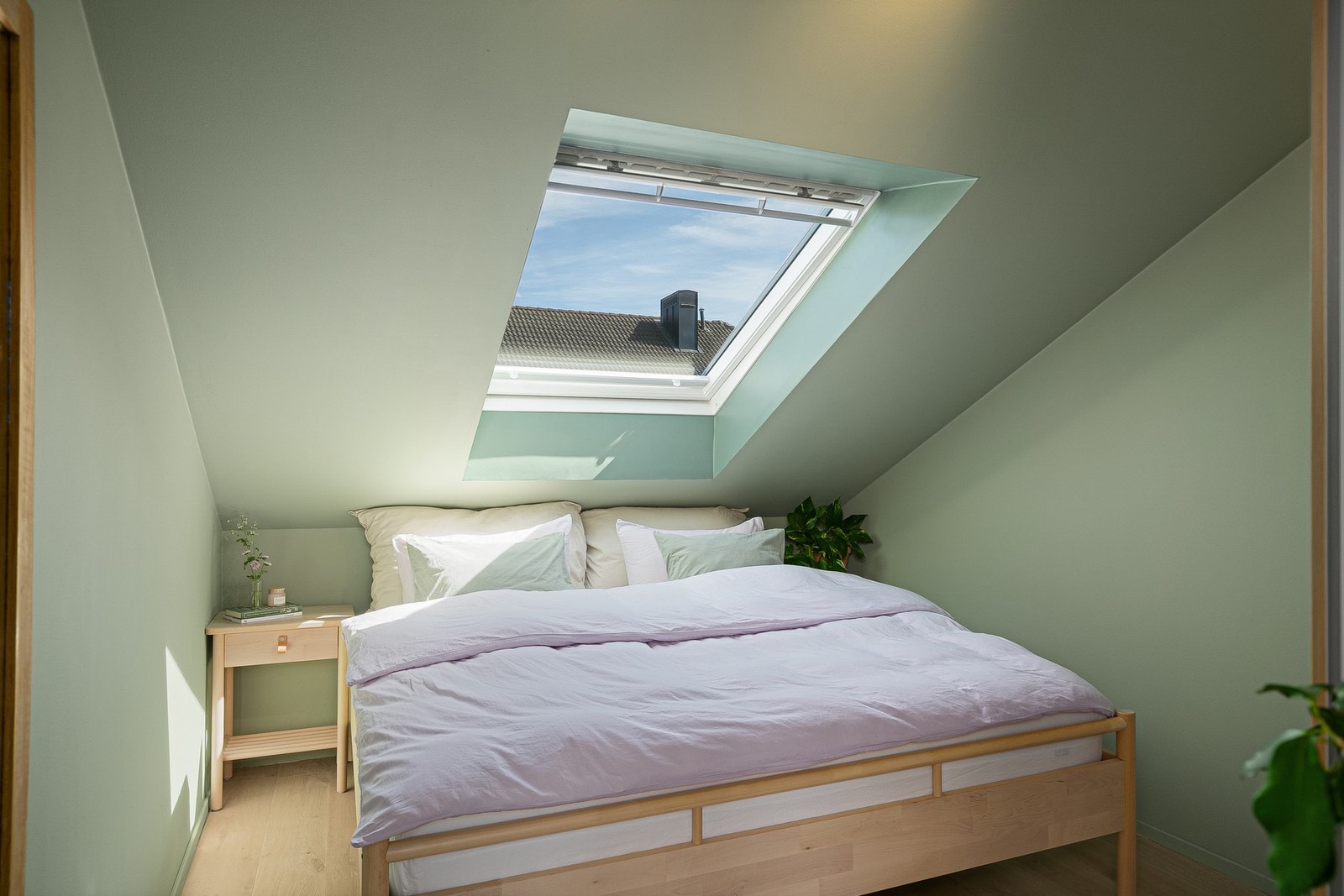 Soverommet er malt i en dus grønntone og har stort takvindu. Galleribilde