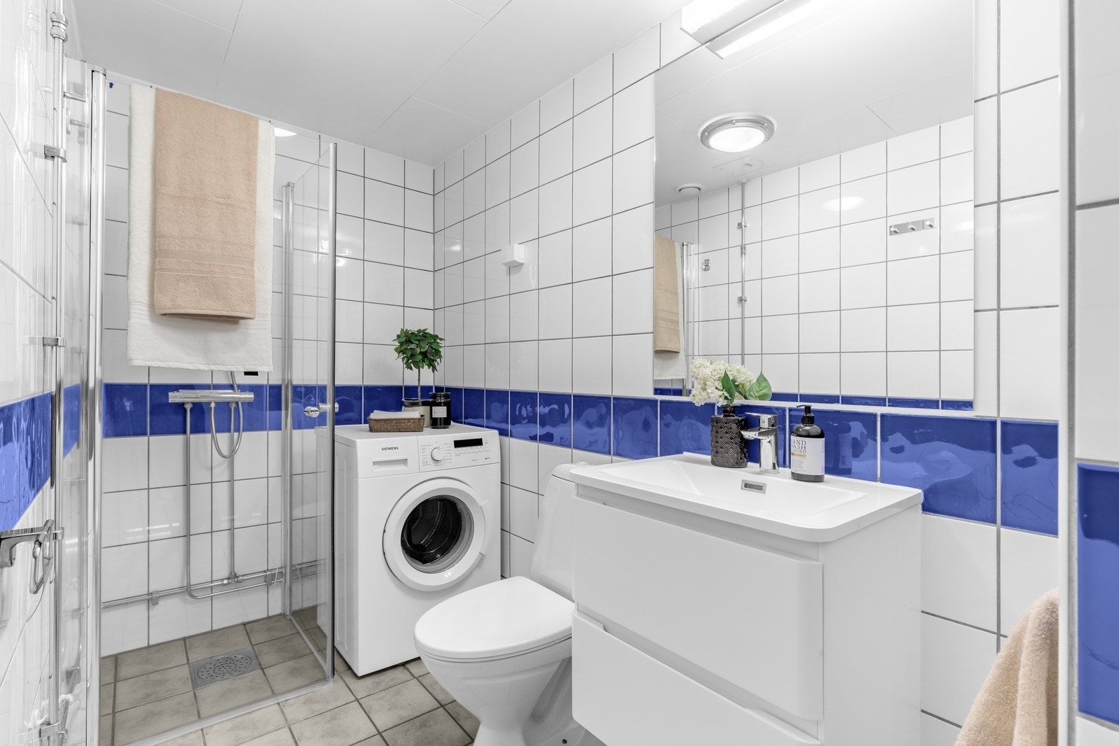 Flislagt bad med varmekabler og vaskemaskin. Galleribilde