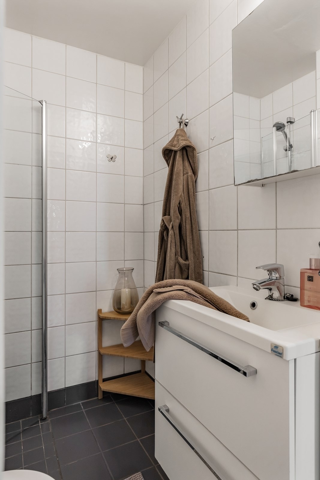 Flislagt bad med dusjhjørne, servant og servantskap. Galleribilde