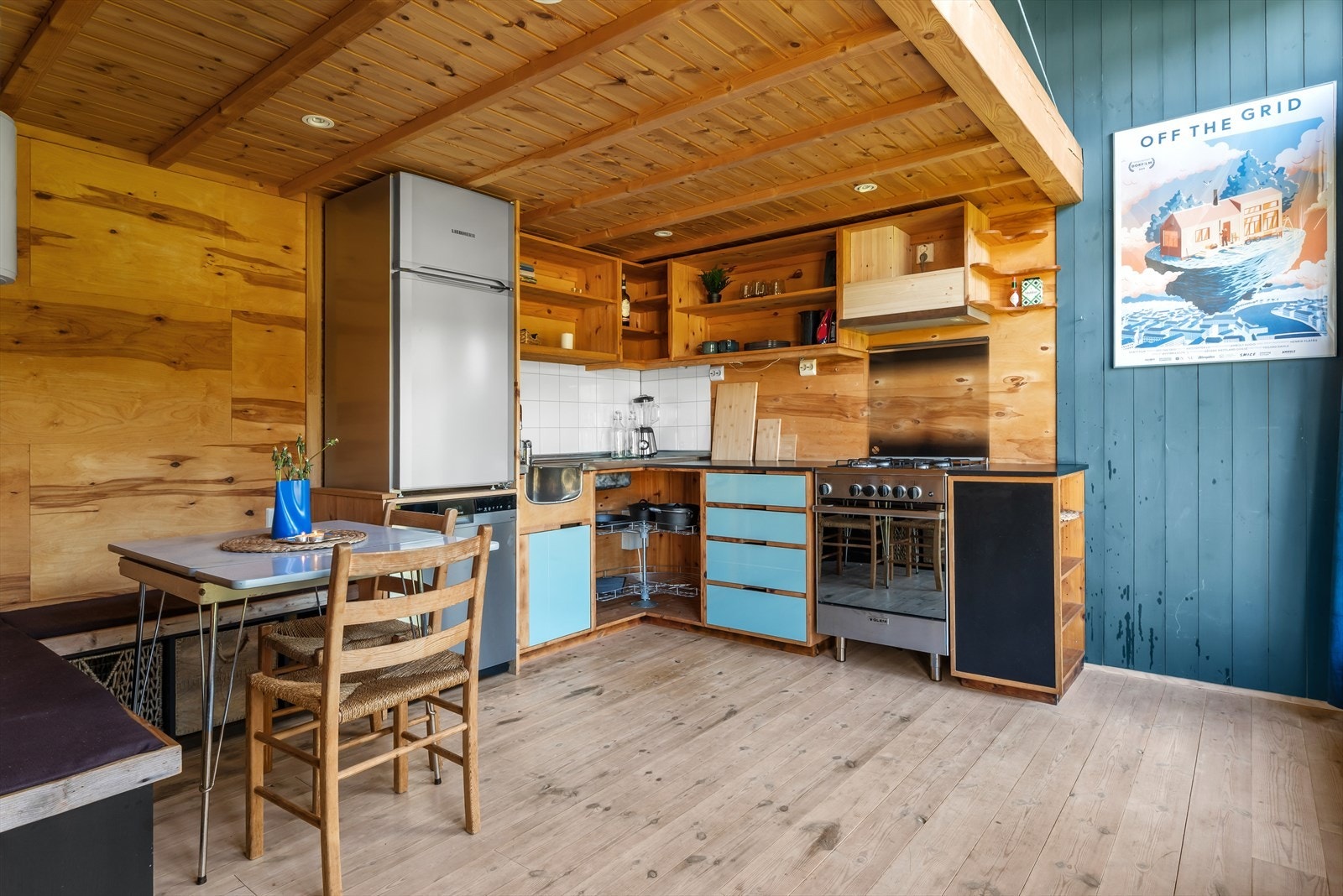 Innredning med opplegg for vaskemaskin og mekanisk avtrekksvifte over stekesonen. Det er integrert gassbluss og stekovn. Galleribilde