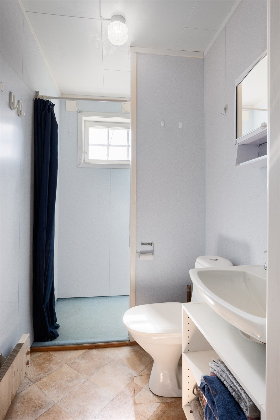 Badet har plater på vegg og belegg på gulv, og har enkelt interiør. Galleribilde