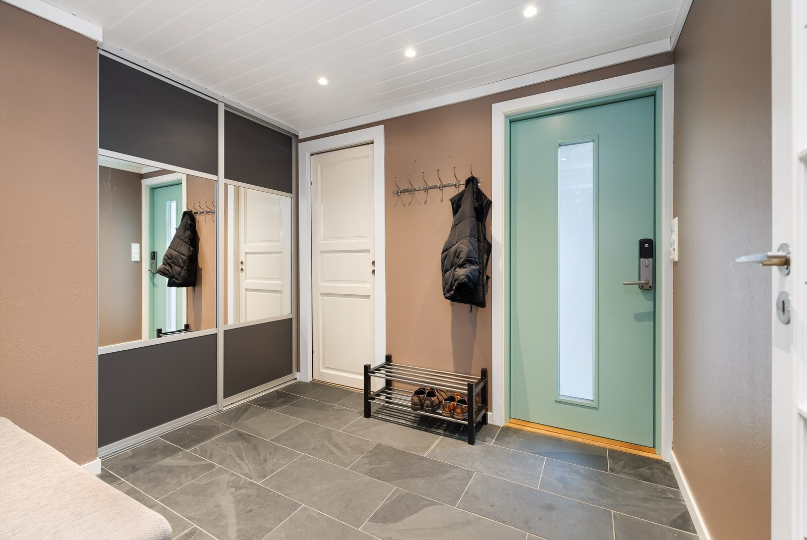 Entréen har flotte skiferfliser på gulvet med varme i gulvet. Stor skyvedørsgarderobe for ytterbekledning. Galleribilde