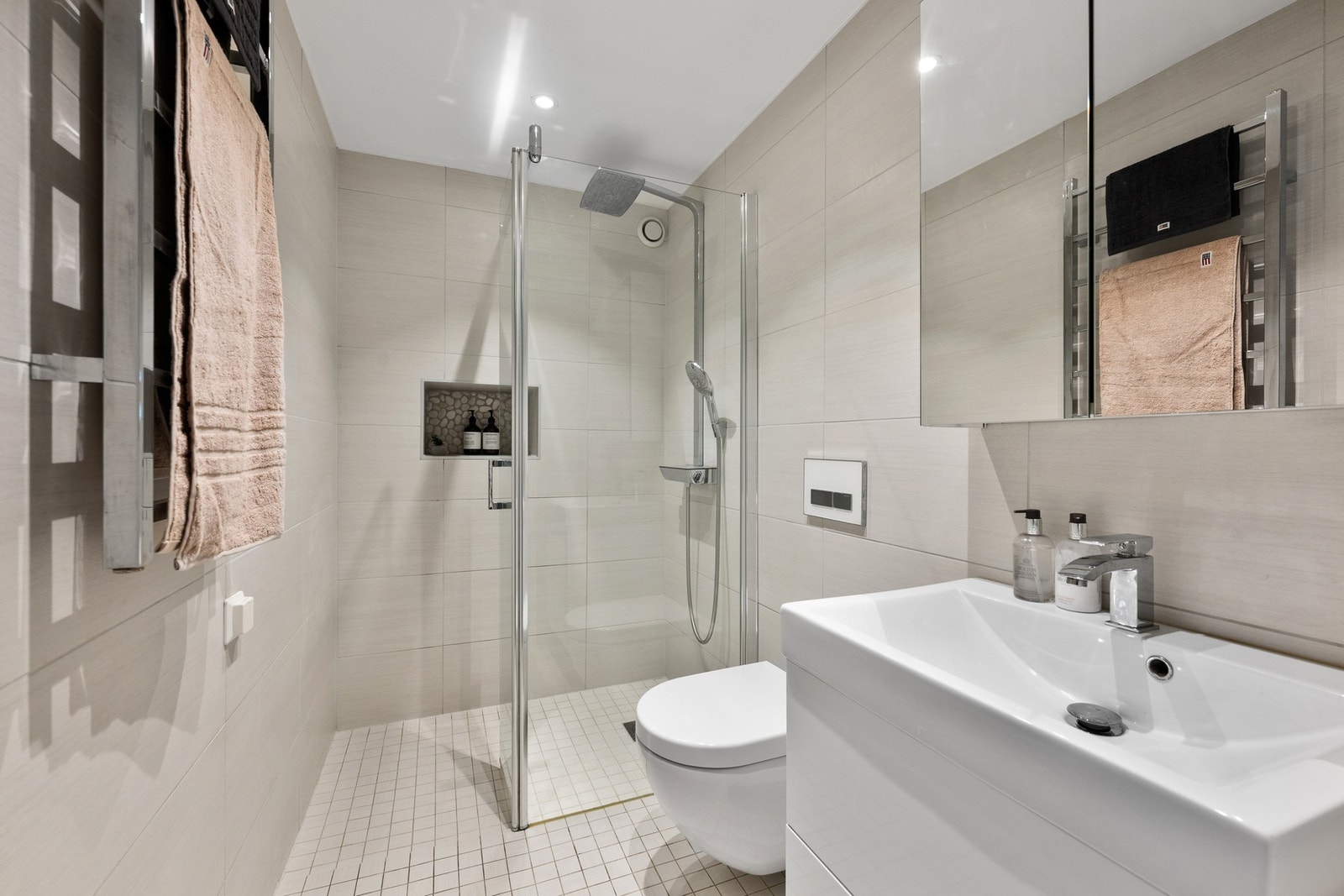 Dusjbadet ligger praktisk til ved entréen og ble pusset opp i 2017. Det har dusjnisje med glassvegg, vegghengt toalett og innredning i samme stil som hovedbadet. Galleribilde