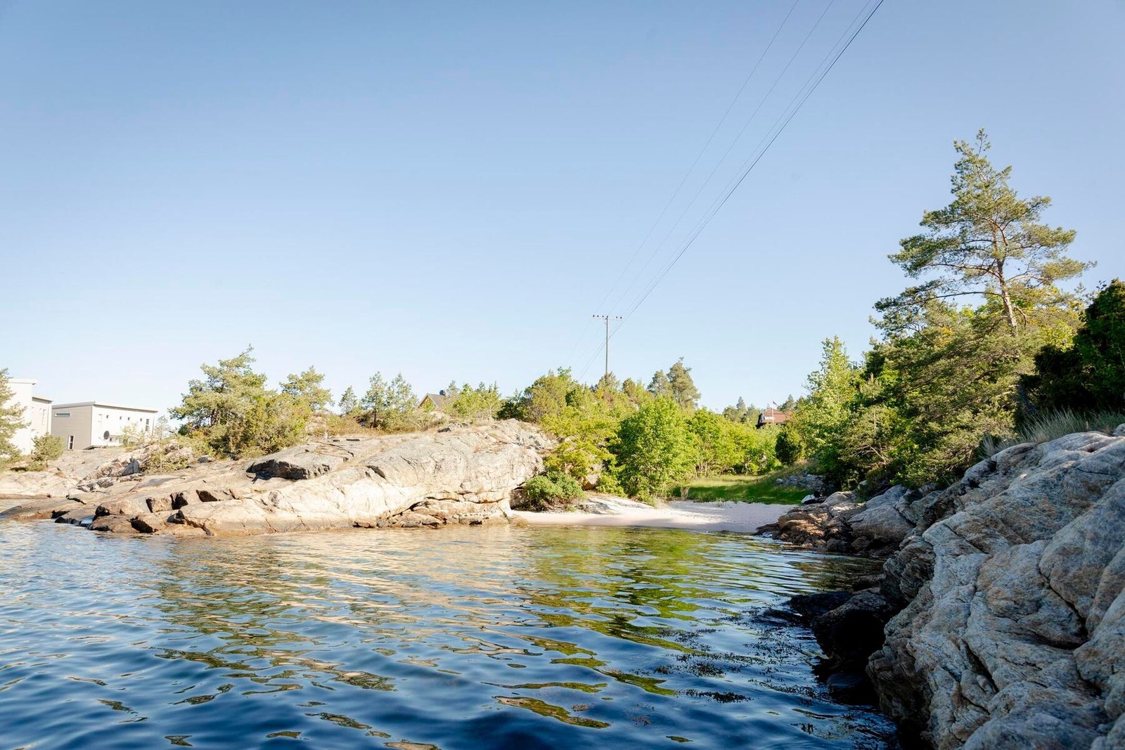 Foto fra badeplassen nedenfor hyttetomtene. Fin vik med sandstrand. Galleribilde