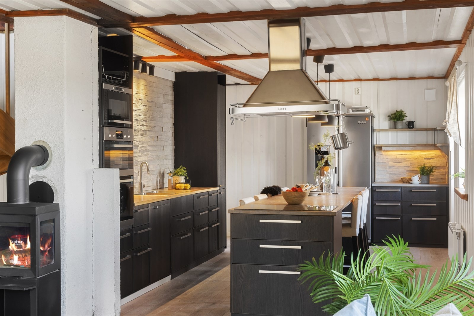 De glatte frontene gir et rent og tidløst uttrykk, mens benkeplaten i heltre tilfører varme og karakter. Galleribilde