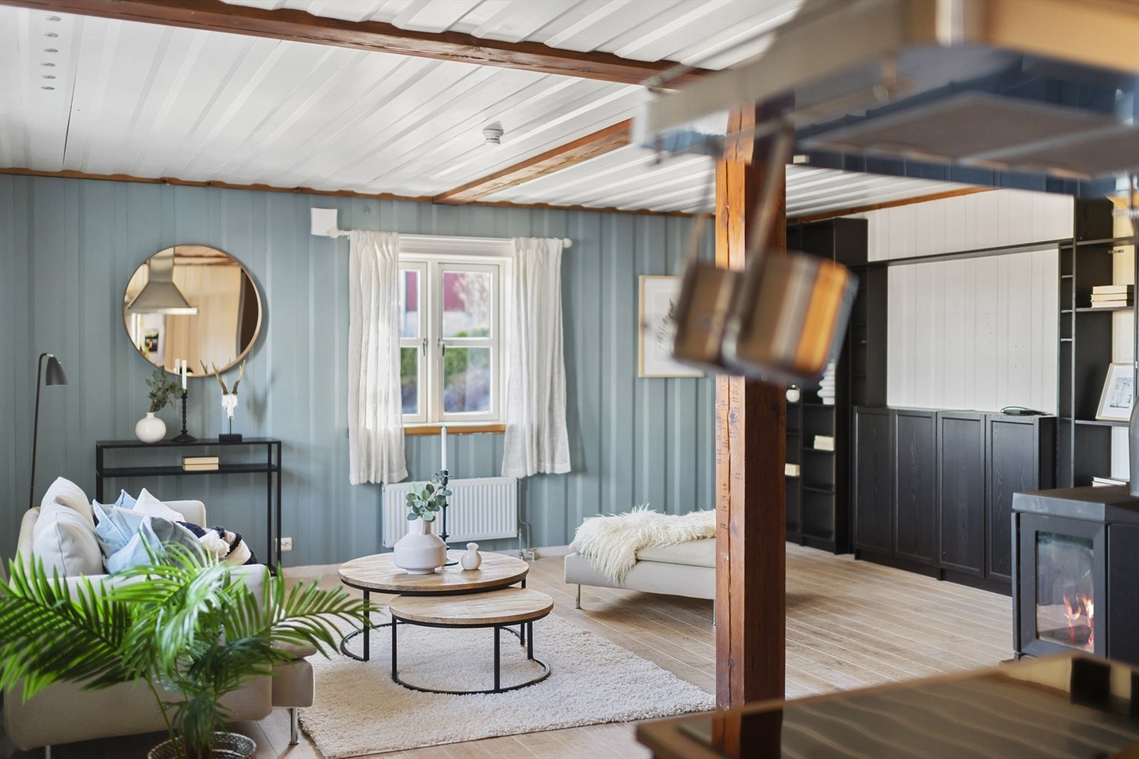 Stuen har en gjennomført og lun atmosfære med lyse, delikate farger på veggene og en flott kontrastvegg som gir rommet karakter og dybde. Galleribilde