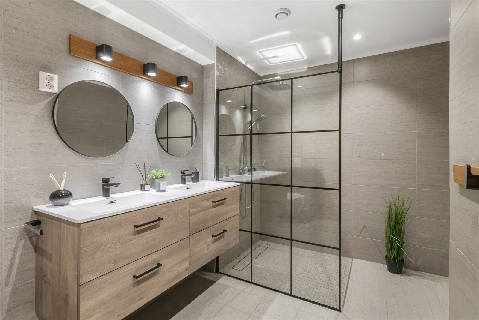 Badet er påkostet og stilrent innredet med fliser på veggene og flislagt gulv med behagelig vannbåren gulvvarme. Taket har malte plater og innfelte downlights som gir god belysning. Galleribilde