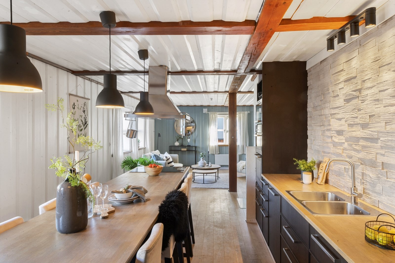 Den store benkeflaten midt i rommet fungerer både som arbeidsstasjon og samlingspunkt - perfekt for matlaging og sosialt samvær. Galleribilde