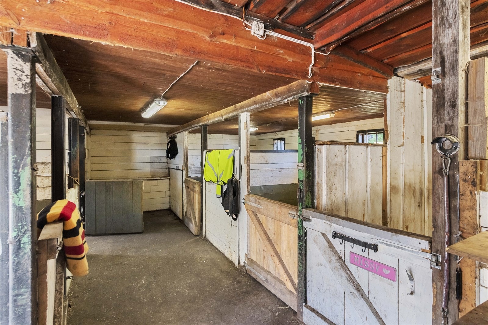 Utvendig er stallen kledd med stående villmarkspanel som gir et rustikt og naturlig preg, godt tilpasset omgivelsene. Saltaket er tekket med slitesterke stål- og aluminiumsplater, og har takrenner i stål for effektiv drenering. Galleribilde