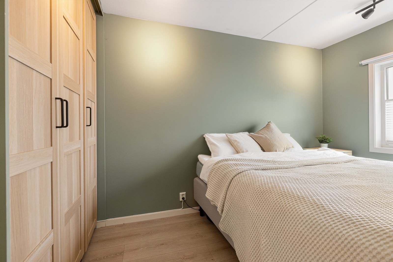 Stort vindu sikrer godt med lys og luft. Soverommet er malt i en behagelig grønntone som passer godt med interiøret for øvrig. Galleribilde