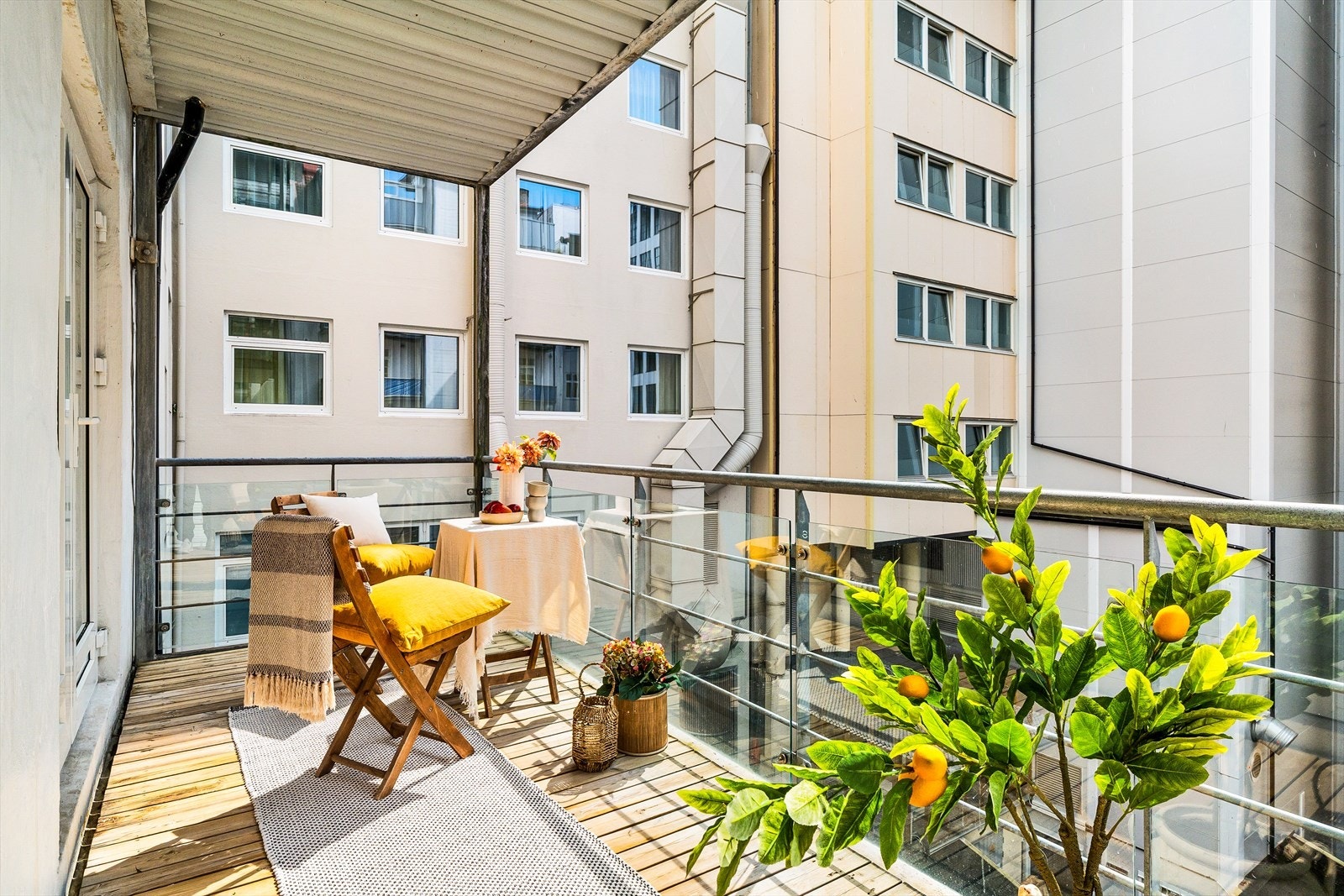 Tenk å ha sin egen uteplass midt i byen - denne private uteplassen har pent dekke med terrassebord. Rekkverket med glassfelt i stålramme Galleribilde