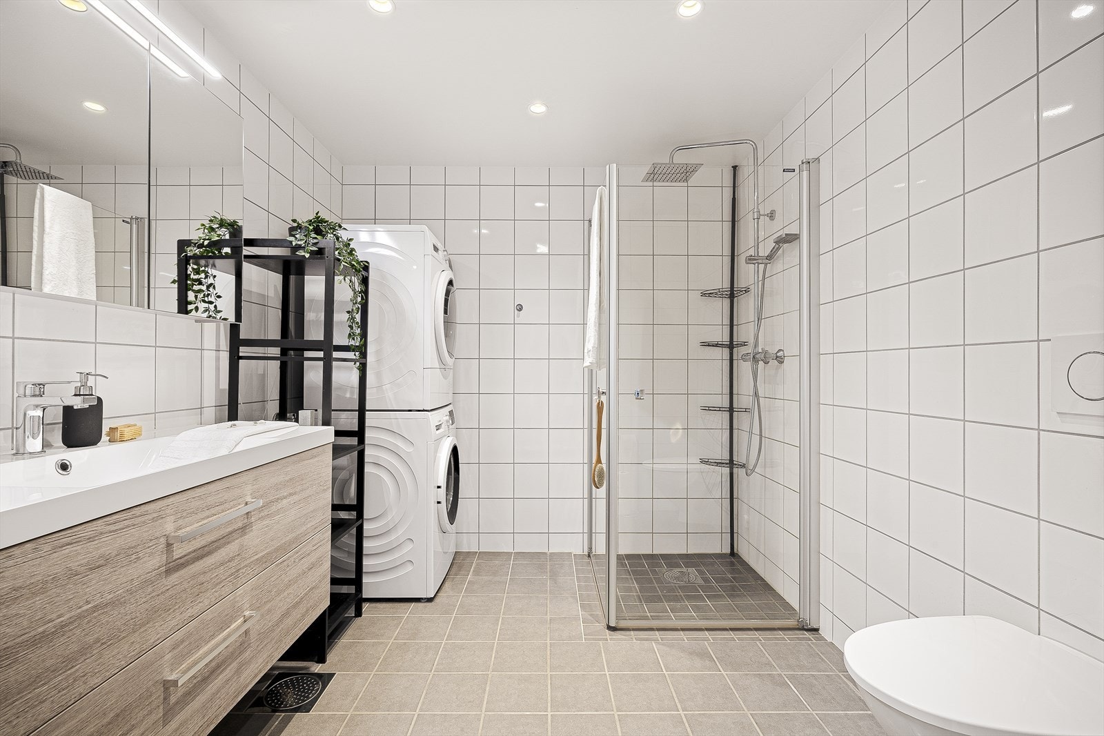 Badet er helfisert, og innredet med møblement/speil, belysning, vegghengt toalett, dusjgarnityr og innfellbart dusjhjørne. Galleribilde