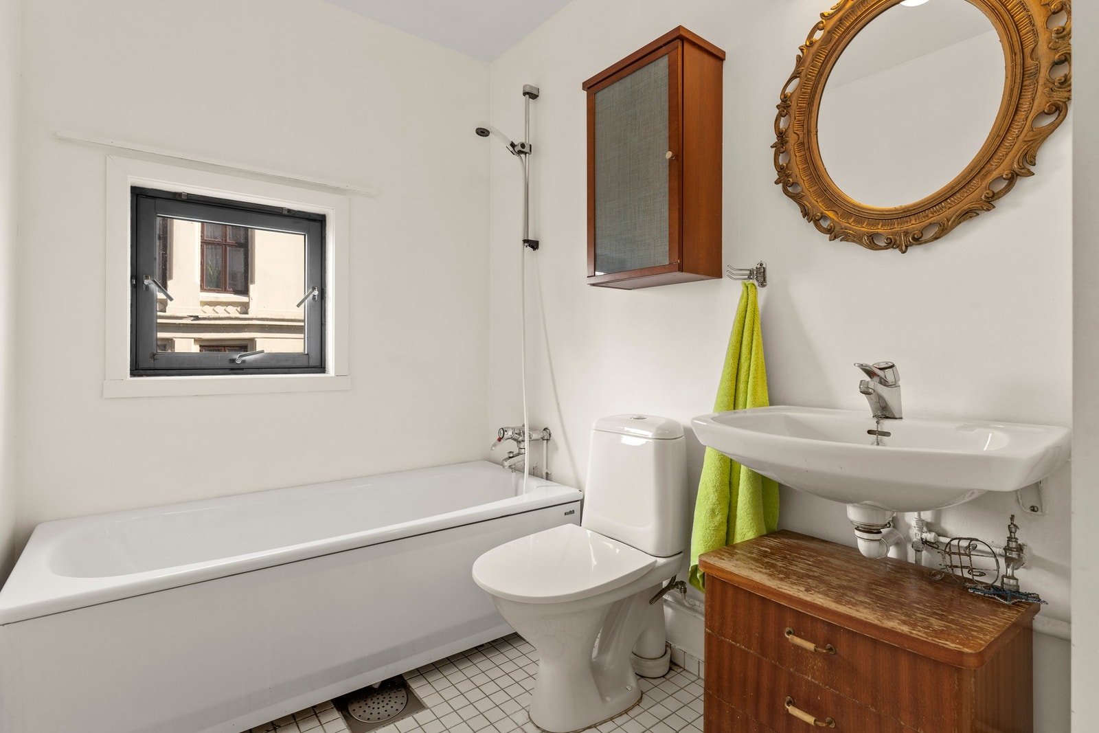 Baderom fra byggeår med behov for oppussing. Badet har flislagt gulv og malt tapet. Galleribilde