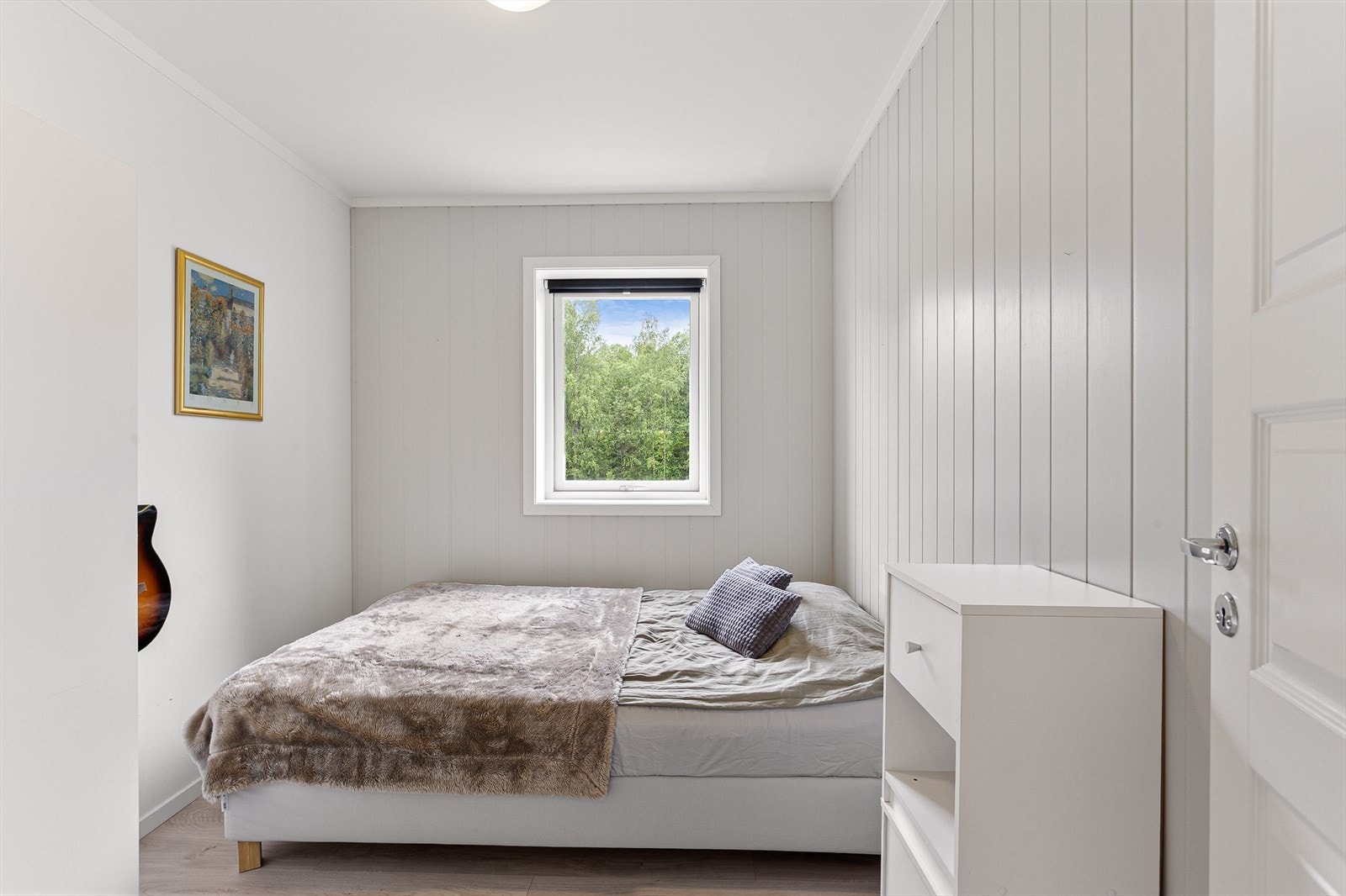 Soverom med malte mdf-plater og laminat på gulvet. Galleribilde
