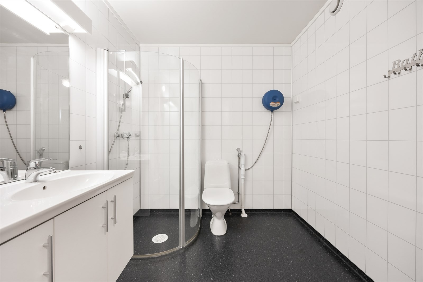 Badet er utstyrt med toalett, servant med skap og dusjnisje med innfellbare glassdører. Galleribilde