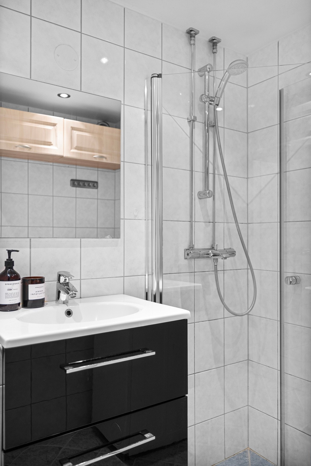 Tidsriktig baderomsinnredning med veggehengt servant med skap, vegghengt klosett, samt dusjhjørne med innfellbare glassvegger. Galleribilde