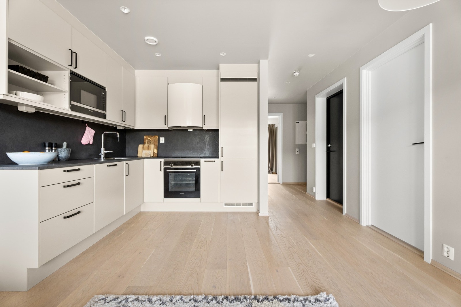 Kjøkkeninnredning med slette fronter og høye overskap Galleribilde