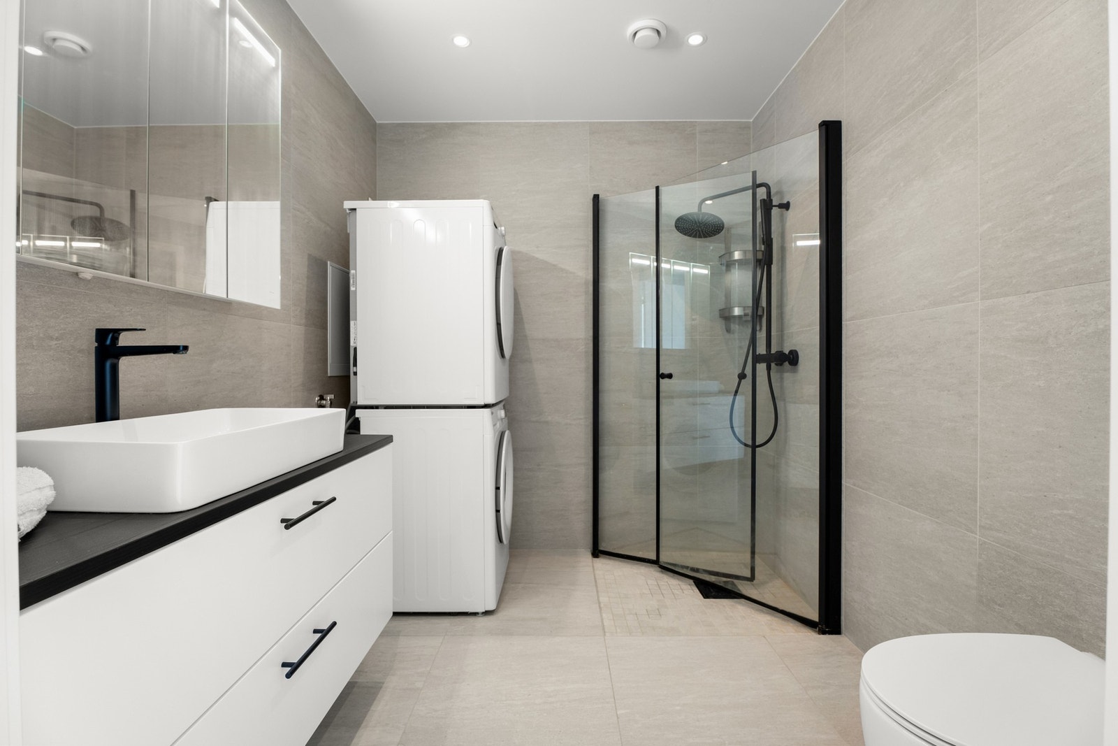 Innredning med skuffeseksjon og servant, dusj med to-veis glassdører og vegghengt toalett Galleribilde