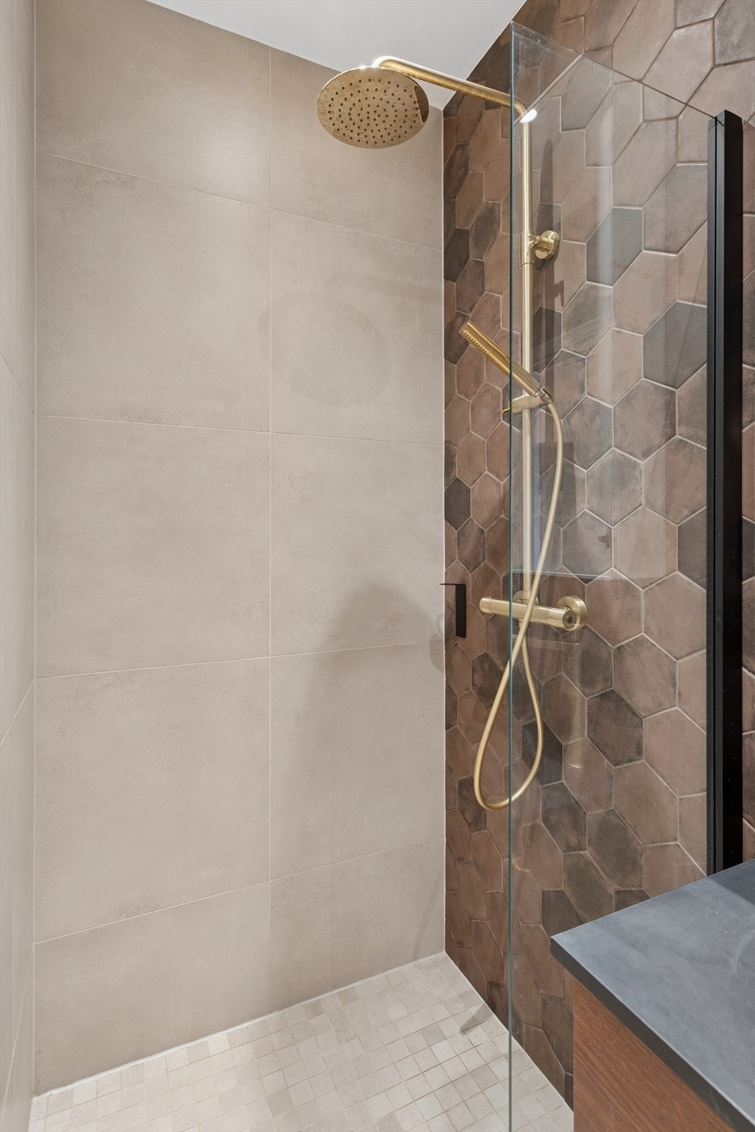 Badet har lekre overflater med store, beige fliser, samt én vegg med hexagon-fliser. Galleribilde