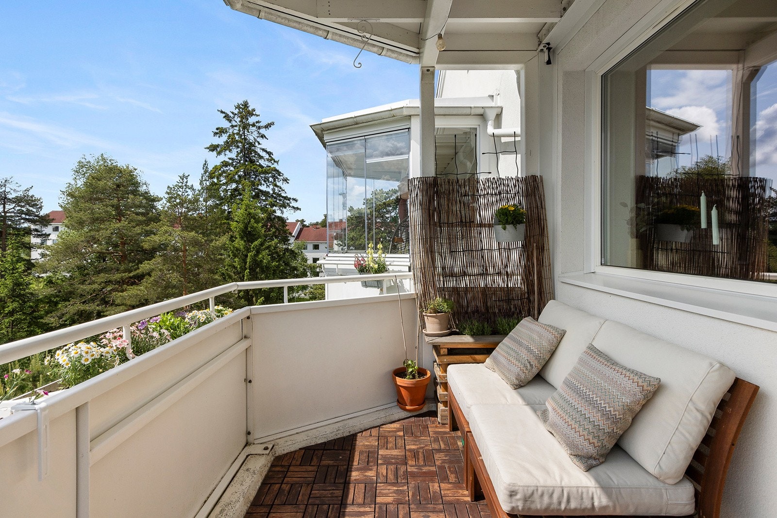 Adkomst fra stue til en sydvendt balkong med trefliser på gulv på ca. 7 m². Galleribilde