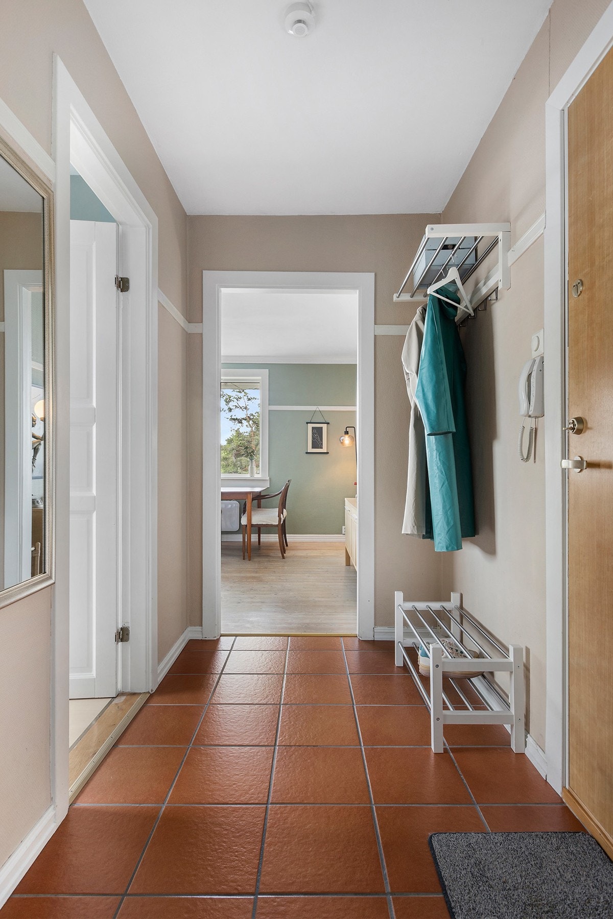 Lun og innbydende entré som ønsker deg velkommen inn i boligen. Her er det plass til å henge fra seg yttertøyet. Galleribilde