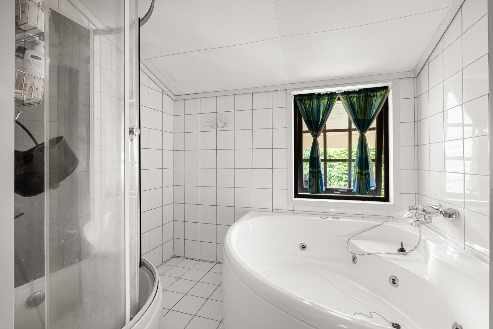 Badet er helfliset og har både badekar og dusjkabinett. Galleribilde