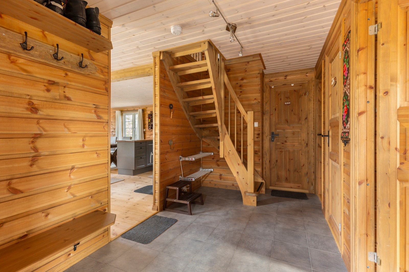 På venstre side når du kommer inn i gangen er det praktiske hyller og god plass til å henge fra seg yttertøy. Vinkeltrapp i gangen opp til loftsetasjen. Galleribilde