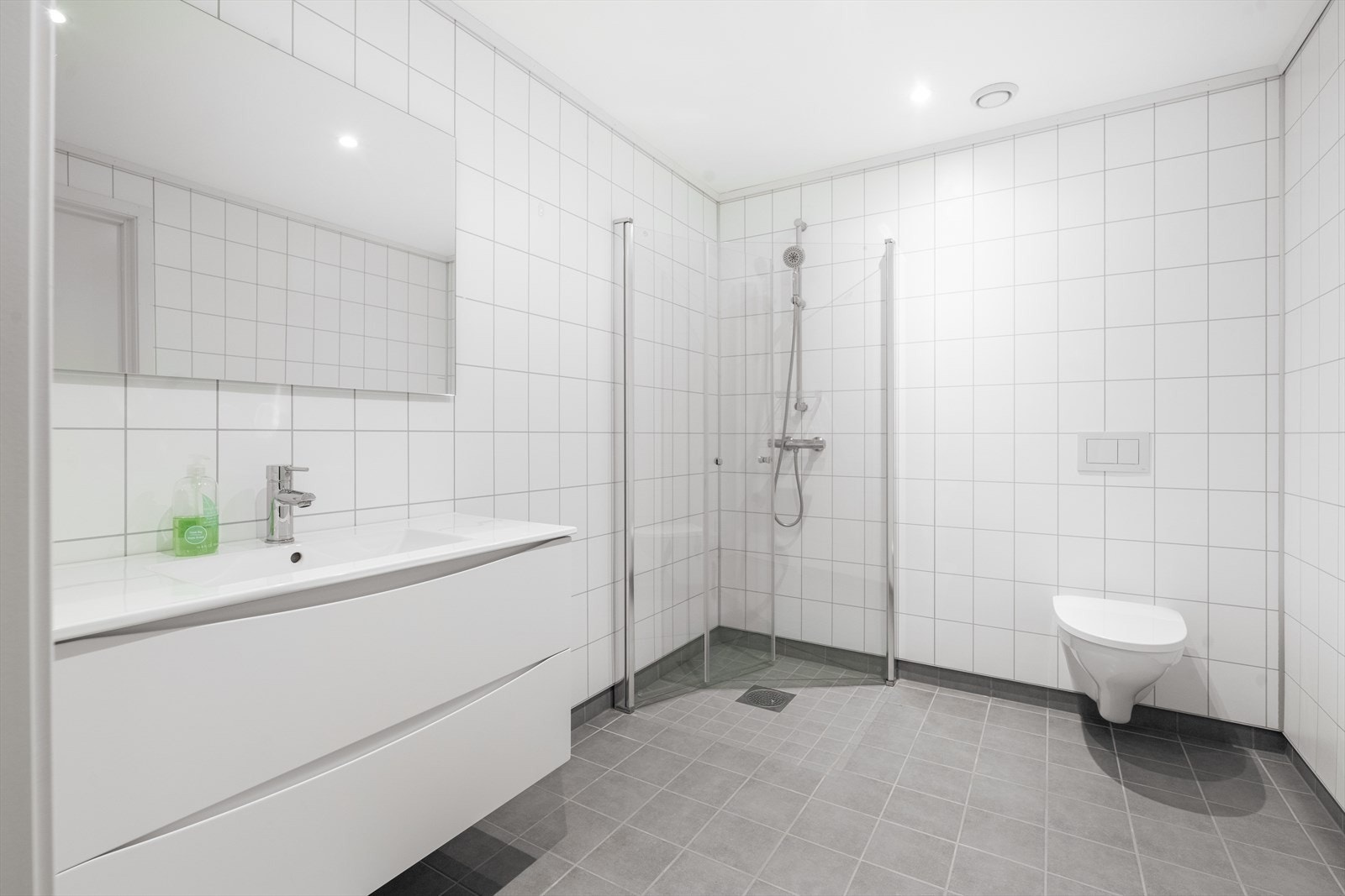 Leiligheten har et romslig bad med flislagt gulv og baderomsplater på veggoverflatene. Galleribilde